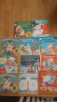 Photo showing multiple Christmas-themed 45 RPM records with colorful illustrated covers including Santa Claus and Frosty the Snowman.