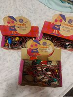 Three open cardboard boxes with vintage GE indoor Christmas light sets, showing the bulbs and wiring inside each box.