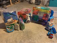 Wide shot of the entire lot showing both cages and accessories on a floor surface in a storage-like area.