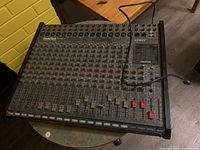 Front view of SoundTech ST-162T mixing console showing 16 channels with faders and knobs.