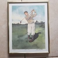 Full view of the framed watercolor artwork showing golfer Bobby Jones in a mid-swing pose on a green golf course under a partly cloudy blue sky.