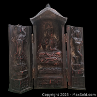 Opened view of the triptych shrine showing central Buddha figure seated and two side panels with devotees.