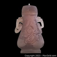 Front view of pink carved jade urn showing dragon symbol and side handles.