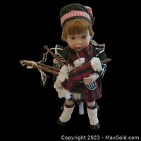 Front view of the porcelain doll Ian, showing detailed traditional Scottish attire and bagpipes