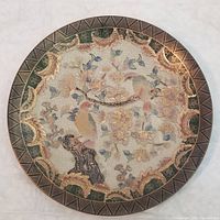 Full view of the round decorative plate showing the birds, flowers, gold accents, and patterned outer rim.
