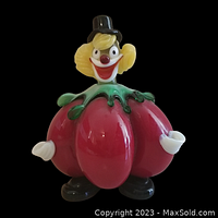 Front view of the Murano glass sculpture depicting clown with a red tomato-shaped body, yellow head, black top hat, and white hands.