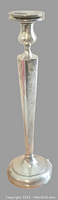 Full view of sterling silver candlestick showing top candle holder, engraved stem, and rounded base.