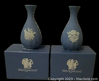 Pair of Wedgwood jasperware blue fluted bud vases on original Wedgwood boxes showing front view with different white floral relief decorations on each.