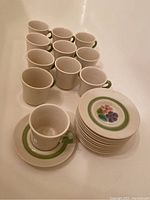 Overview of 11 cups, 11 saucers stacked, and some additional dishes