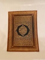 Top view of brown leather book cover showing ornate gold embossed Moroccan pattern.