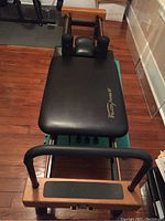 Top view of Pilates Premier XP reformer showing black padded carriage and wooden foot bar.