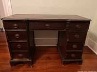 Full front view of vintage wooden desk showing drawers and overall structure
