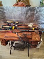 Overview of fishing rods collection laid out on a table with fishing net.