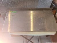 Top view of stainless steel shelf showing surface wear and scratch marks with dimension label 18" x 32".