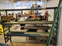 Front view of assembled steel shelving unit showing three particle board shelves and frame
