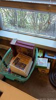 Overview of basket containing books and boxed sets by window