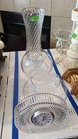 Photo showing clear twisted ribbed crystal vase approximately 14 inches tall, along with two medium clear glass bowls and Mikasa crystal table clock on white surface.