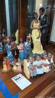 Photo showing entire set of six figurines including the 12 inch couple and five smaller ones in colorful dresses and suits.