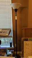 Full view of the tall floor lamp near a window and keyboard
