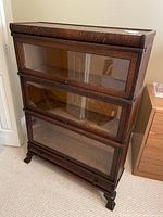 Front view of three-shelf barrister bookcase on carved feet