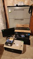 Photo showing Canon MP220 printer, black HP monitor, keyboard, and computer tower stacked in basement environment.