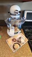 Front view of mixer with bowl and manual for scale