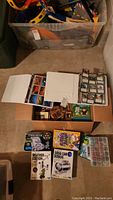 Photo showing open binders and box containing multiple trading cards including Magic The Gathering, Yu-Gi-Oh!, and baseball cards.
