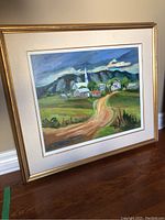 Front view of the framed and matted painting leaning against a wall on wood floor