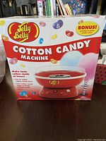 Photo of new Jelly Belly Cotton Candy Machine in original packaging showing product image and bonus cotton candy cones included.
