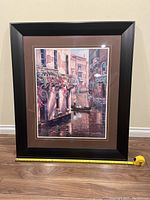 Framed full view of the painting showing Venetian canal scene with gondola and buildings, black frame with brown matte.