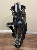Front angle showing multiple compartments, Mizuno logo, and attached black strap accessory.