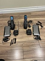 Two complete sets of MX-890 universal remotes with charging bases, power adapters, RF receiver antenna and cables laid on floor.