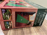 Box for Putt n Hazard electronic putting green showing product images and description on wood floor.