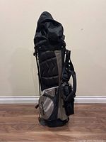 Front view of the golf bag with the top cover extended, showing the structure, zippered pockets, and shoulder strap.