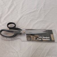 Left-handed scissors in clear plastic blister packaging with size 8.5 inch and label in English and French