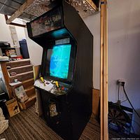 Front-left angled view of black Raiden II arcade cabinet in basement setting