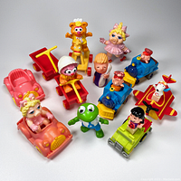 Photo of 15 colorful small plastic fast food premium toys featuring Muppet Babies and Charlie Brown Peanuts characters. Multiple vehicles include cars, scooter, trains, airplane, and tractor. Toys are used and untested.