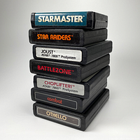 Stack of seven Atari video game cartridges showing title labels on cartridge ends.