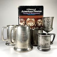 All five vessels grouped with the book in background showing inscriptions and designs clearly.