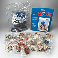 Photo showing the sealed 1996 Patrick Roy mini goalie mask, the 1991 Canplay Upper Deck Vancouver Canucks hockey team card set in blue packaging, and multiple plastic-sealed NHL hockey team pins.
