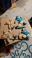 Four metal football player plaques arranged on cardboard showing overall condition and paint loss.
