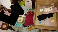 Photo showing a variety of jewelry display items including black velvet necklace bust, pink velvet bracelet displays, and other mixed display stands scattered and stacked.