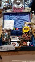 Full view of vintage jewelry box with jars, containers, and assorted jewelry parts mainly beads, bracelets, and earrings, some damaged