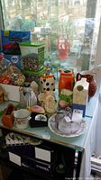 Wide shot of assortment including pitchers, plates, and decorative pieces on a surface.