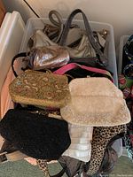 Collection of vintage ladies handbags in plastic tubs, showing a variety of evening bags and purses including beaded and sequin details