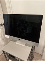 Front view of powered-off iMac on stand showing overall condition