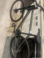Overview side view of matte black Cannondale Bad Boy 3 bicycle, highlighting frame, wheels, pedals