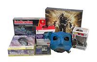 Photo shows assortment of items including Coinstruction Submarine model kit, Micro Optical mouse, ergonomic game pad, blue dinosaur mask, and Pop Vinyl figure.