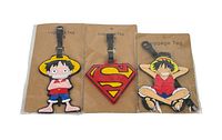 Three luggage tags still sealed on brown backing cards showing Superman logo and two anime characters.