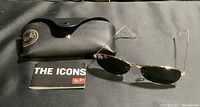 Full lot showing the Ray-Ban sunglasses, black leather protective case with gold logo, and Ray-Ban booklet.